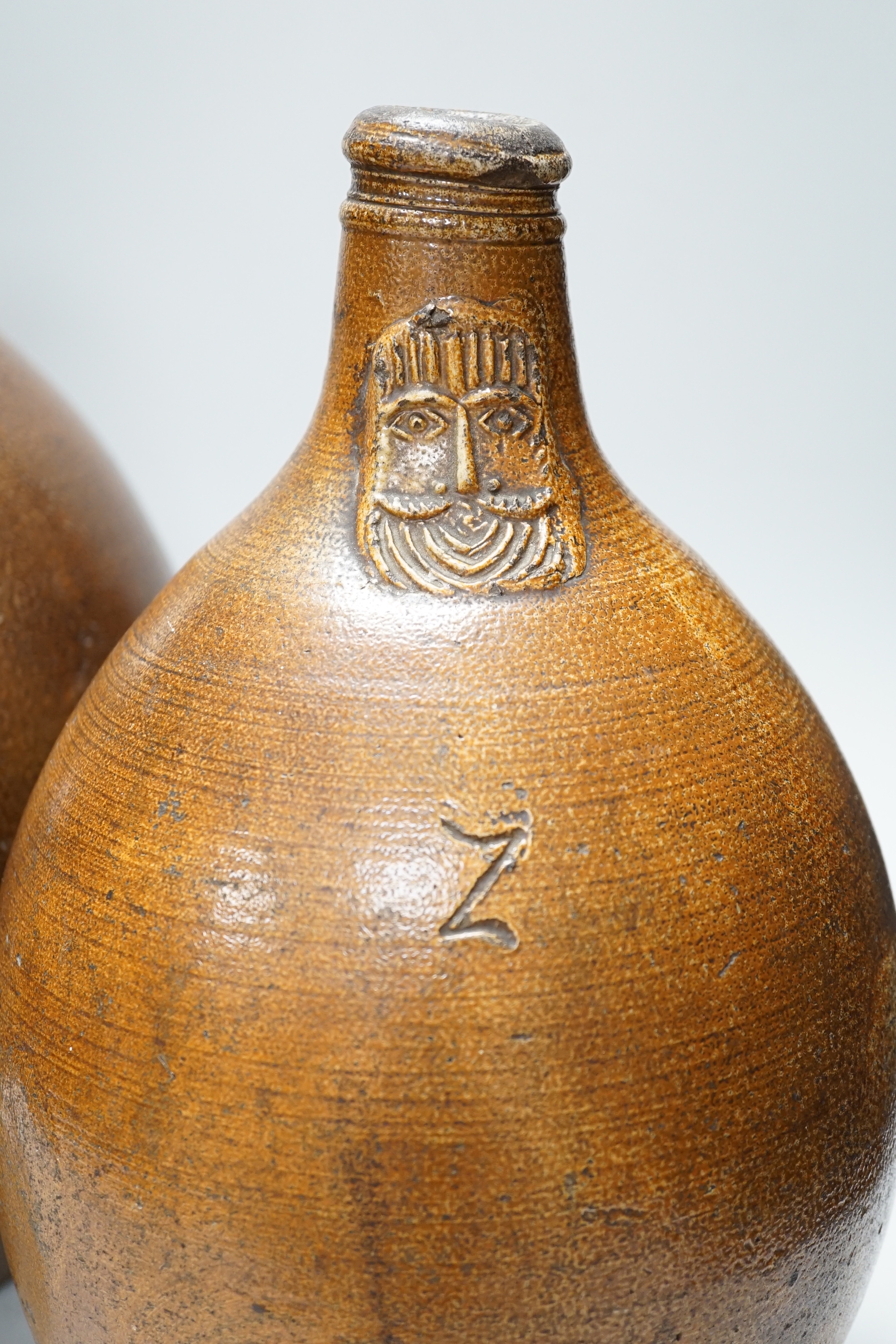 A large 17th century stoneware Bellarmine, incised Z, 42cm high and a large 18th century stoneware jug, 34cm high